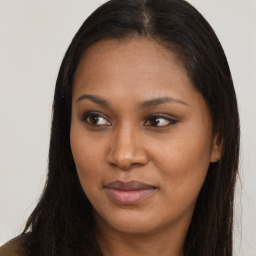 Joyful black young-adult female with long  brown hair and brown eyes