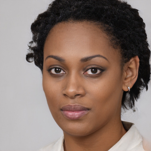 Joyful black young-adult female with short  black hair and brown eyes