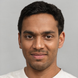 Joyful black young-adult male with short  black hair and brown eyes