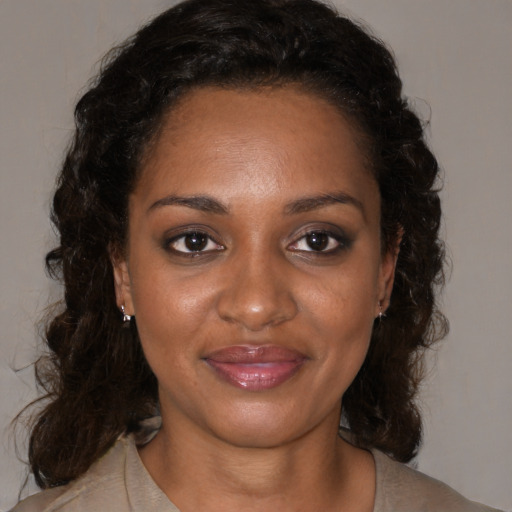 Joyful black young-adult female with medium  brown hair and brown eyes