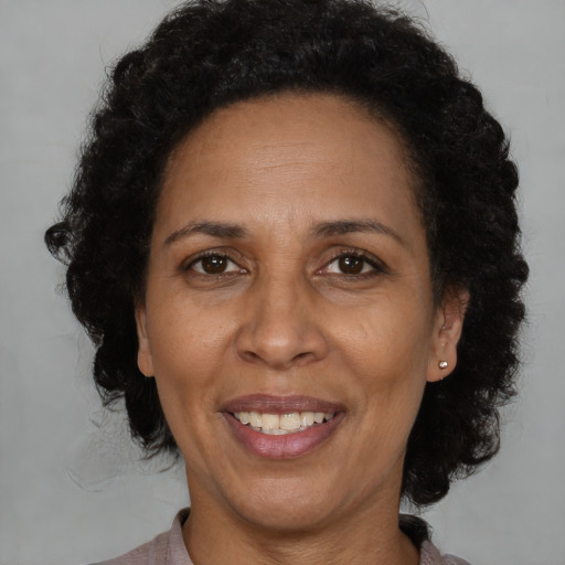 Joyful latino adult female with medium  brown hair and brown eyes