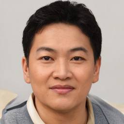 Joyful asian young-adult male with short  black hair and brown eyes