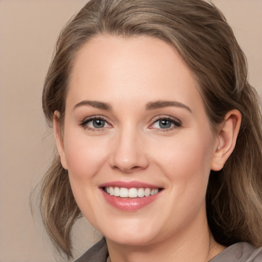 Joyful white young-adult female with medium  brown hair and grey eyes