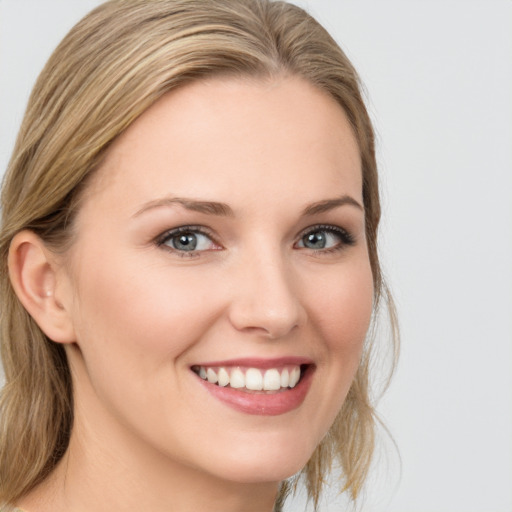 Joyful white young-adult female with medium  brown hair and blue eyes