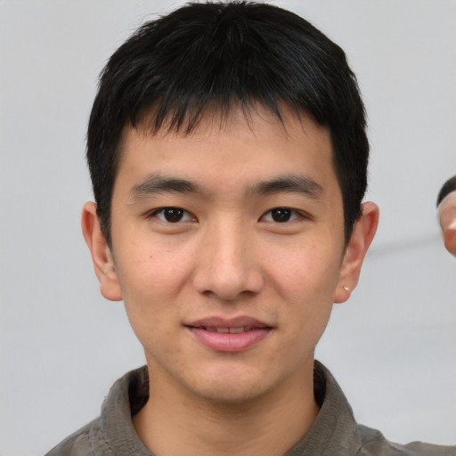 Joyful asian young-adult male with short  brown hair and brown eyes
