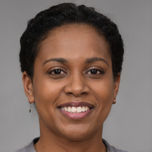 Joyful black young-adult female with short  brown hair and brown eyes