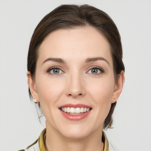 Joyful white young-adult female with medium  brown hair and grey eyes