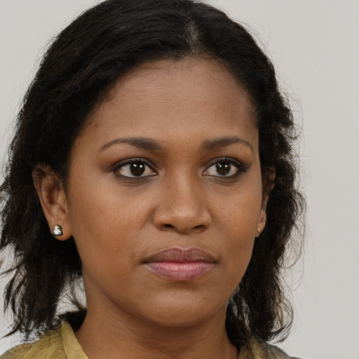 Joyful black young-adult female with long  brown hair and brown eyes