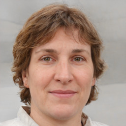 Joyful white adult female with medium  brown hair and grey eyes