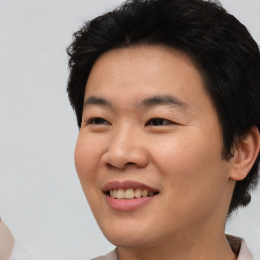 Joyful asian young-adult male with short  black hair and brown eyes