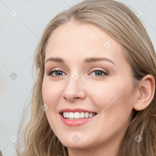 Joyful white young-adult female with long  brown hair and blue eyes