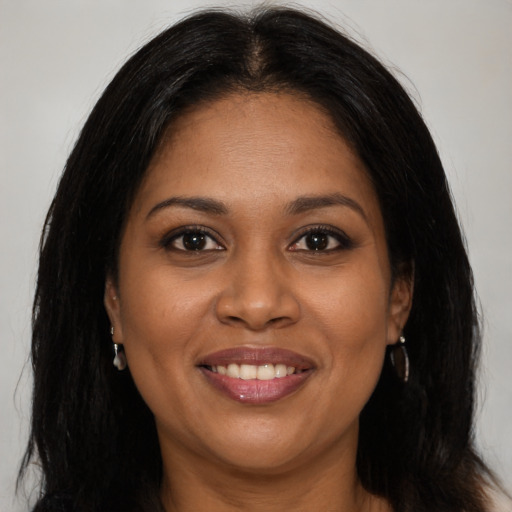Joyful black young-adult female with long  brown hair and brown eyes