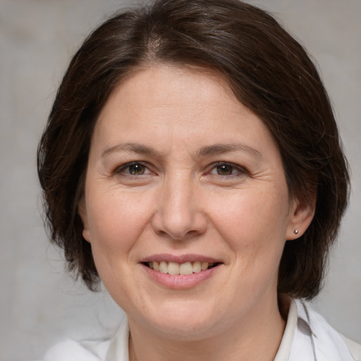 Joyful white adult female with medium  brown hair and brown eyes