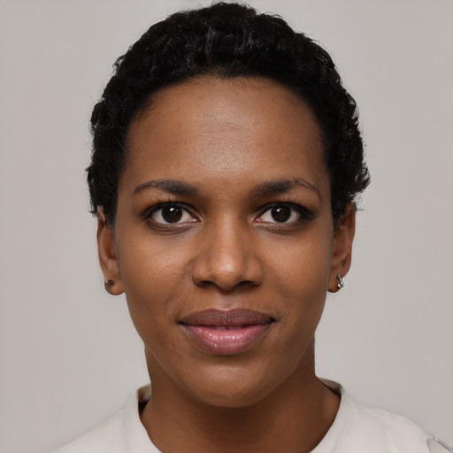 Joyful black young-adult female with short  black hair and brown eyes