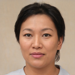 Joyful asian adult female with medium  brown hair and brown eyes