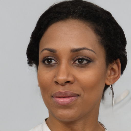 Joyful black young-adult female with short  black hair and brown eyes