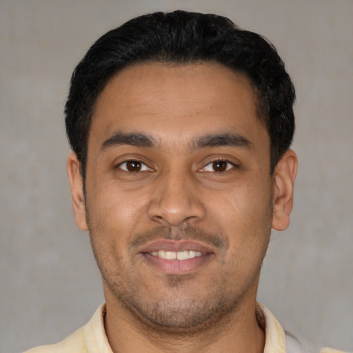 Joyful latino young-adult male with short  black hair and brown eyes