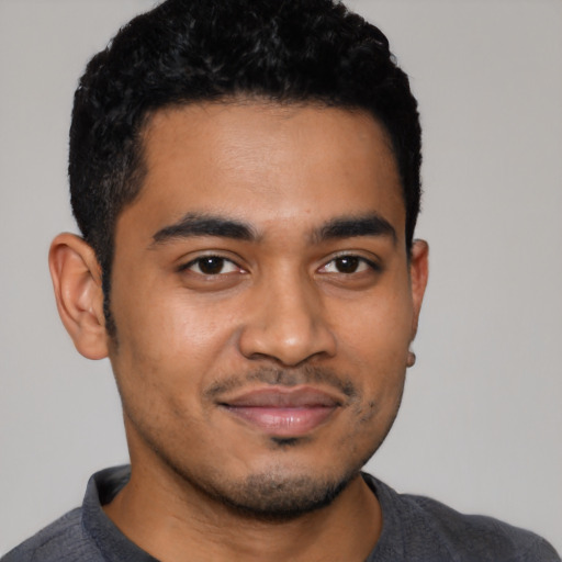 Joyful latino young-adult male with short  black hair and brown eyes