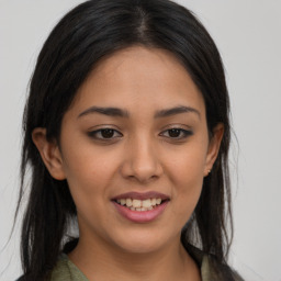 Joyful latino young-adult female with long  brown hair and brown eyes