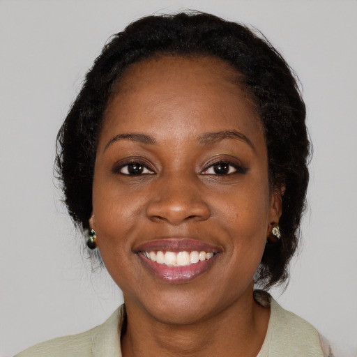 Joyful black adult female with medium  black hair and brown eyes