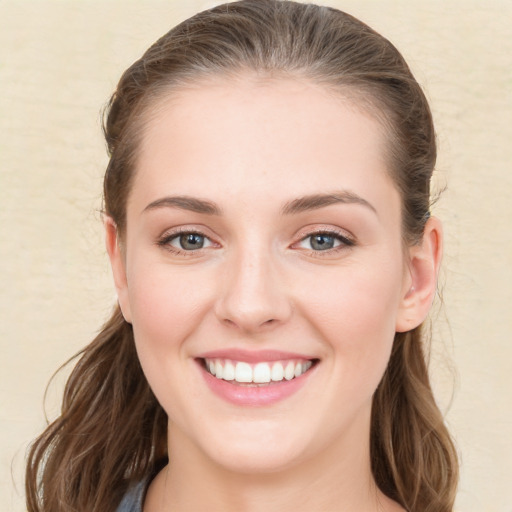 Joyful white young-adult female with long  brown hair and blue eyes