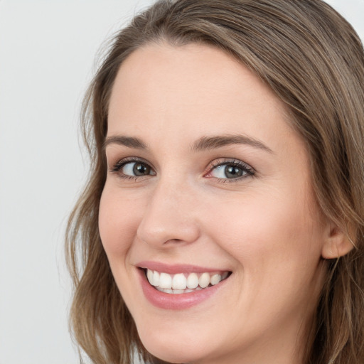 Joyful white young-adult female with long  brown hair and blue eyes