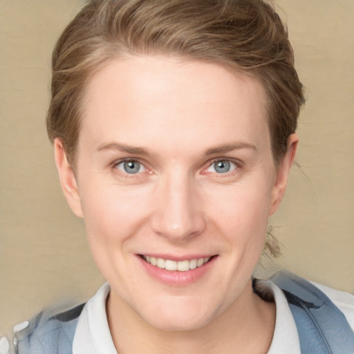 Joyful white young-adult female with short  brown hair and blue eyes