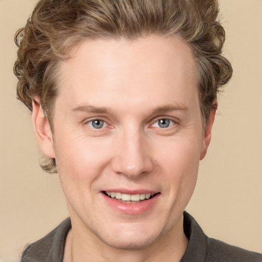 Joyful white adult male with short  brown hair and grey eyes