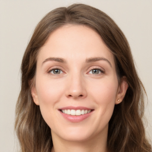 Joyful white young-adult female with long  brown hair and grey eyes