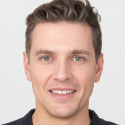 Joyful white young-adult male with short  brown hair and grey eyes