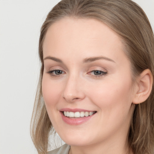 Joyful white young-adult female with long  brown hair and blue eyes