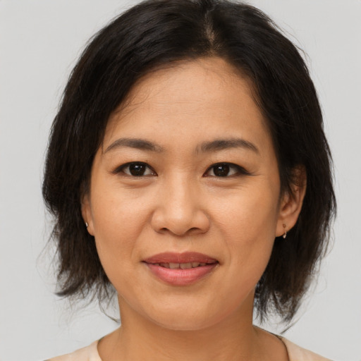 Joyful asian adult female with medium  brown hair and brown eyes