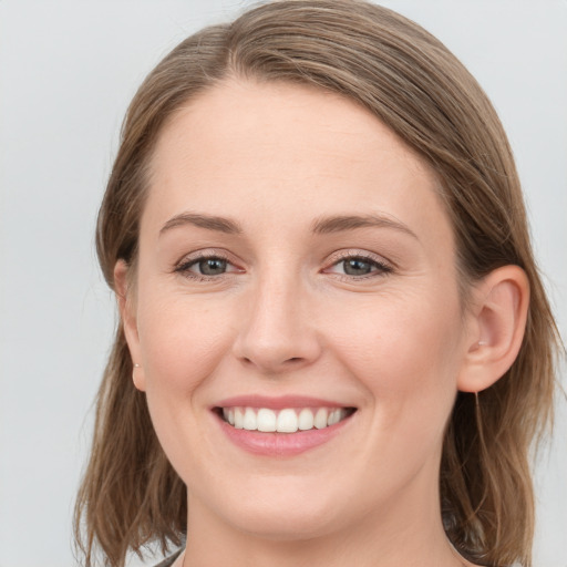 Joyful white young-adult female with medium  brown hair and blue eyes