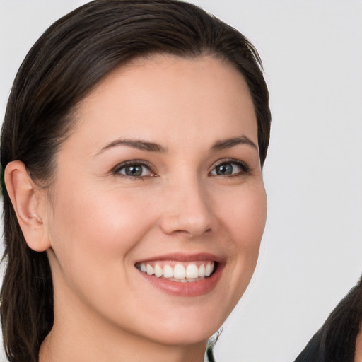 Joyful white young-adult female with long  brown hair and brown eyes