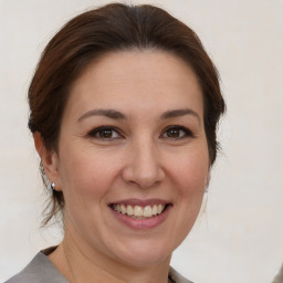 Joyful white adult female with medium  brown hair and brown eyes