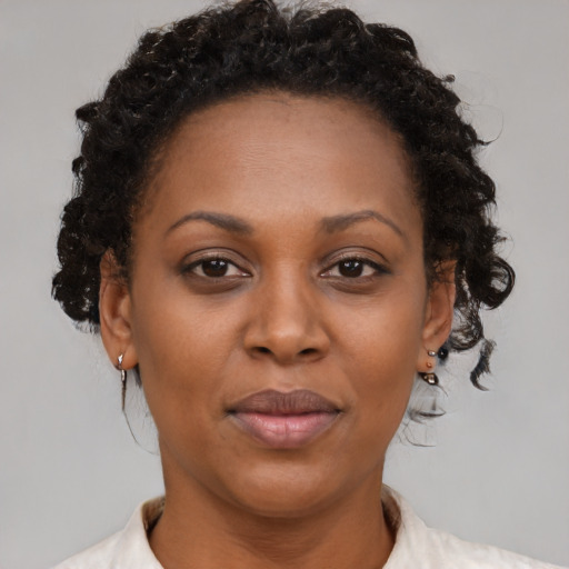 Joyful black adult female with short  brown hair and brown eyes