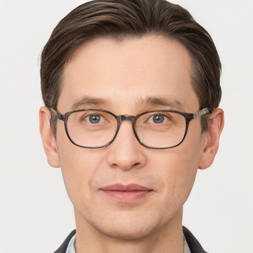 Joyful white young-adult male with short  brown hair and grey eyes