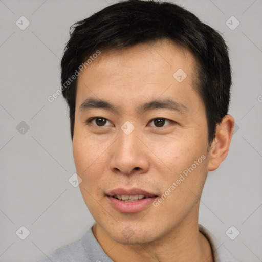 Joyful asian young-adult male with short  brown hair and brown eyes