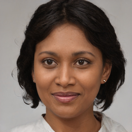 Joyful black young-adult female with medium  brown hair and brown eyes