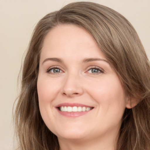 Joyful white young-adult female with long  brown hair and green eyes