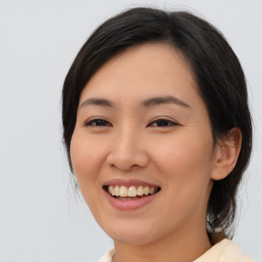 Joyful asian young-adult female with medium  black hair and brown eyes