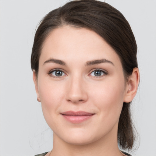 Joyful white young-adult female with medium  brown hair and grey eyes