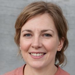 Joyful white adult female with medium  brown hair and grey eyes