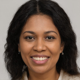 Joyful black young-adult female with long  brown hair and brown eyes