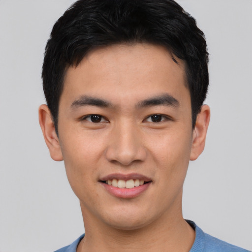 Joyful asian young-adult male with short  black hair and brown eyes
