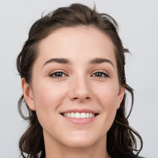 Joyful white young-adult female with medium  brown hair and grey eyes