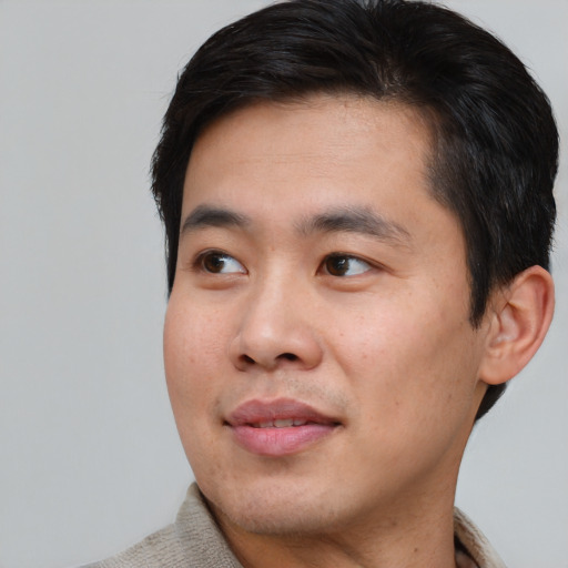 Joyful asian young-adult male with short  black hair and brown eyes