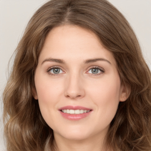 Joyful white young-adult female with long  brown hair and green eyes