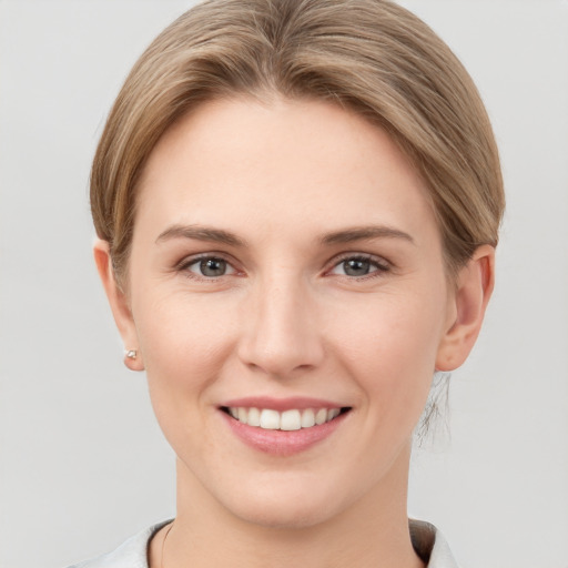 Joyful white young-adult female with short  brown hair and grey eyes