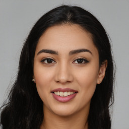 Joyful latino young-adult female with long  brown hair and brown eyes